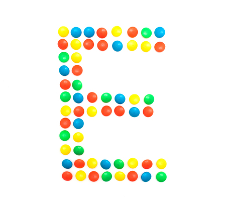 Multi-colored vitamins pills that are lined with the letter Vitamin E, close-up, medicamentの写真素材