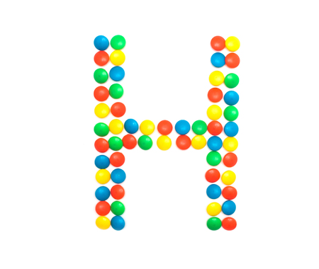 Multi-colored vitamins pills that are lined with the letter Vitamin H, close-up, medicamentの写真素材
