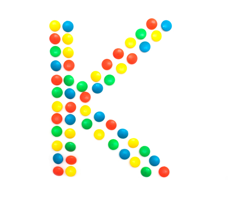 Multi-colored vitamins pills that are lined with the letter Vitamin K, close-up, medicamentの写真素材