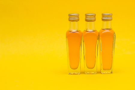 Small bottles with alcohol on a yellow background, close-up, copy space, importの写真素材