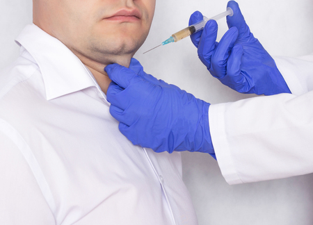 Doctor cosmetologist makes a man an injection of plasma therapy in a double chin, treatment...