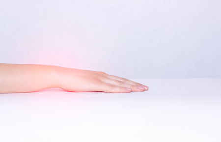 Pain and inflammation in the wrist of a girl, white background, close-up, copy space, ankylosing spondylitis, polyarthritis, rheumatoid arthritisの写真素材