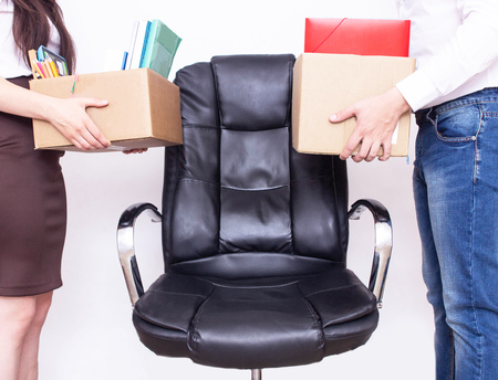 Male and girl office workers stand with their personal belongings for the same workplace concept of competition and unemployment in the workplace, new workplaces, apparatus employedの写真素材