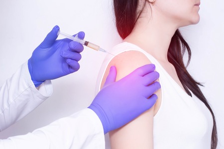 A doctor makes plasma-lifting injections to a patient who has pain and inflammation in the shoulder joint, arthrosis, close-up, polymyalgiaの写真素材