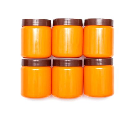 Orange plastic jars with a brown lid on a white background, isolateの写真素材