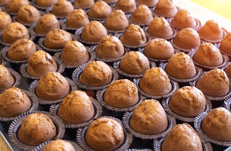 Lots of delicious fresh chocolate muffins muffins on a tray, background, copy space, dessertの写真素材
