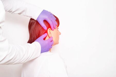 Doctor otolaryngologist examines a girl patient who has earache and inflammation, otitis, pain, epidemicalの写真素材