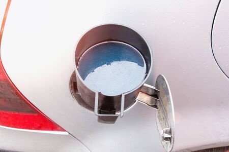 Watering can in which low-quality diesel fuel is poured. Diesel winter fuel concept in cold weather, freezing temperature, autoの写真素材