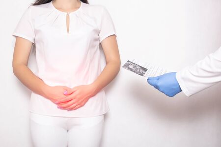 The girl is a patient at a doctor s appointment with a gastroenterologist who holds in her hands the results of a colonoscopy examination. Intestine, colon, colitis disease conceptの写真素材