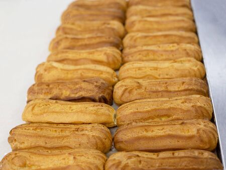 Fresh custard eclairs cakes lie on the table, background, pastry, handmade, delicious