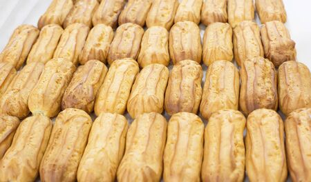 Fresh custard eclairs cakes lie on the table, background, pastry, copy space, sweetness