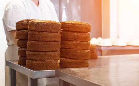 Mass production of cakes and sweets at the confectionery factory. Chefs make cakes of fresh berries and biscuit, food industryの写真素材