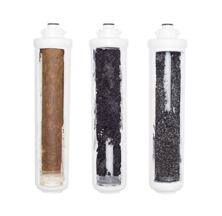 Used water cartridges in section on a white background. The concept of water purification from heavy metals, rust and toxic substances, isolateの写真素材