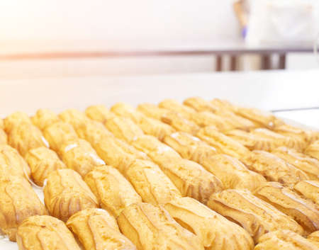 Confectionery for the production of desserts and sweets, making custard cake eclairs with cream and...