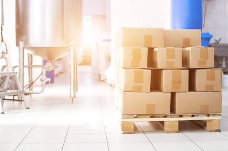Boxes on a pallet with sugar products against the background of production equipment. Sugar beet sugar manufacturing conceptの写真素材