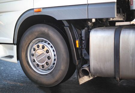 Spinning wheel of a truck and a fuel tank with an exhaust pipe. Road safety concept and adblue...
