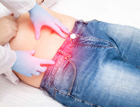 The doctor examines a sick patient who has pain in the right lower abdomen. Concept of inflammation...