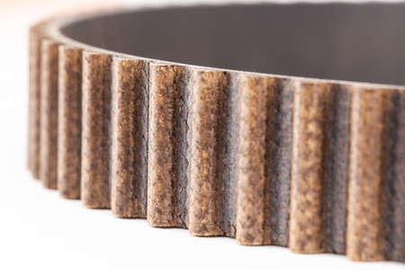 Used timing belt with small cracks. Timing belt replacement schedule. Automotive timing belt on a white background, macro, industrialの写真素材