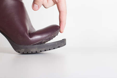 Poor-quality spring-autumn women's shoes in which the sole has come off. White background, close-up