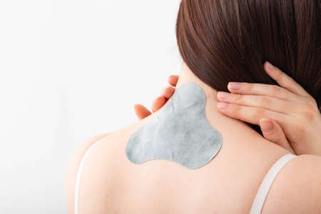 Medical plaster for relieving pain in the neck and spine. Anti-inflammatory with analgesic effect, elimination of muscle spasm in the girl's neckの写真素材