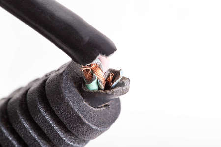 Broken electrical wire with a plug on a white background, isolate, close-up. Electric shock,...
