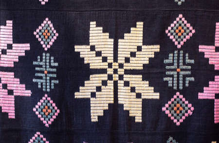 Traditional rustic tablecloth with handmade patterns and embroidery, macro. Texture
