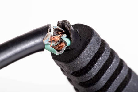 Broken electrical wire with a plug on a white background, isolate, close-up. Electric shock,...