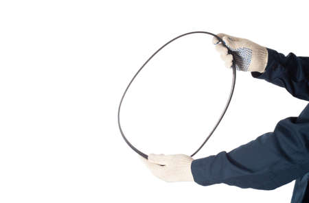 A car mechanic holds a used alternator rivulent belt on a white background, isolate.