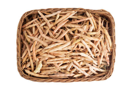 Dry bean pods in a wicker basket on a white background, isolate, organic