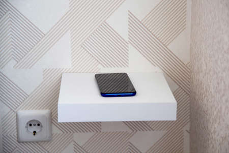 Small shelf near the bed for a smartphone, a convenient interior solutionの写真素材