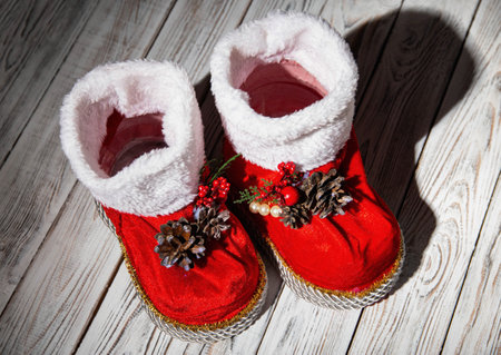 Red santa claus boots on a white wooden background. Handmade new year 2022.