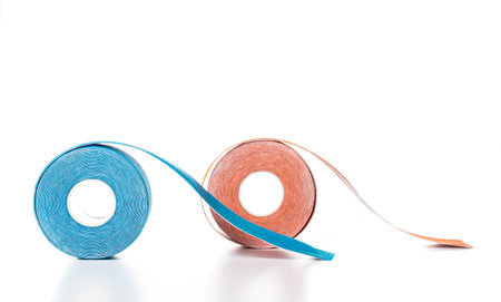 Kinesiology tape for taping in blue and orange on a white background, isolate. close-up treatmentの写真素材