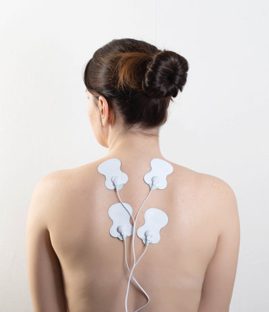Acupuncture electronic massager on the girls back to relax muscles and relieve back pain. Home...