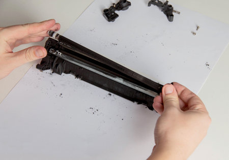 Disassembly of a drum cartridge on a white background. Cleaning and maintaining cartridge parts