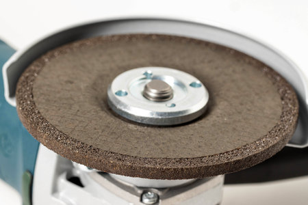 Cleaning reinforced circle on an angle grinder, close-up. Processing and cleaning of stainless...