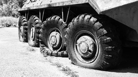 Punctured wheels of an armored personnel carrier after hostilities. Military conflict, war. Black and white photography, transportationの写真素材