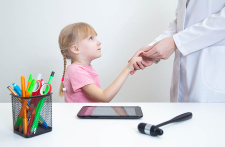 A neurologist doctor checks the pathological reflex of a hoffman in a girl for the presence of neuropathologies. Nervous system, neurologyの写真素材