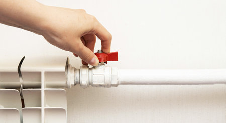 Adjustment of comfortable temperature on the wall radiator in the house. Saving energy resources, increasing the price of gas heating.の写真素材