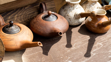 Clay teapots with long spouts and lids. Clay dishes. Copy space for text, pottery