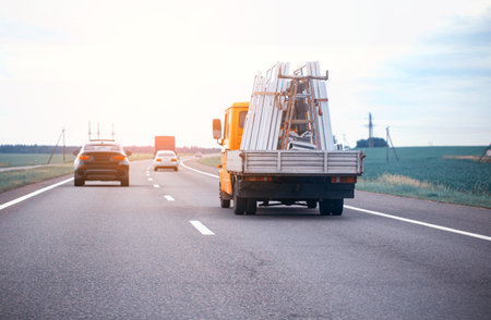 The truck in the company transports pvc windows for their installation. Transportation of pvc windows on the road.の写真素材
