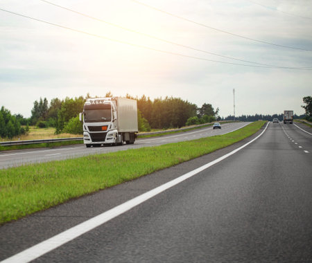 A modern truck with a semi-trailer transports humanitarian aid to another country on a highway. Cargo transportation and logistics.の写真素材