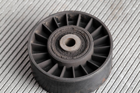 Old dirty car roller made of plastic and bearing on a gray background.の写真素材