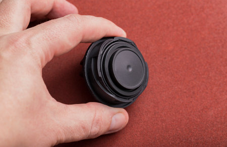 Black car oil filler cap in the mechanic's hand.の写真素材
