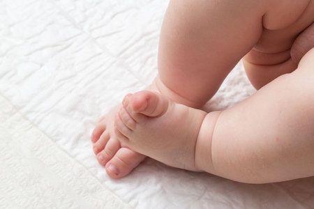 Baby feet on a white background. The concept of baby massage and baby skin care. Copy space for textの写真素材