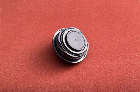 Black car oil filler plug on brown background