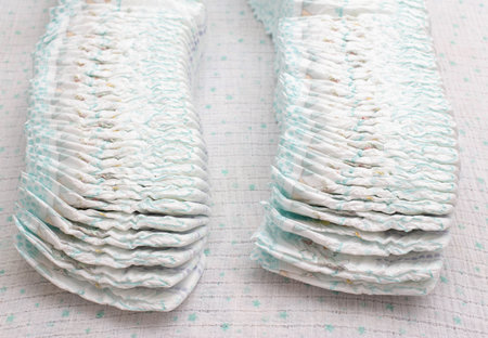 Many stacks of baby soft and comfortable diapers on a white background.の写真素材