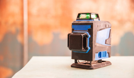 Modern construction laser level against the background of a wall with a concrete contact primer. Repair and decoration of the premises.の写真素材