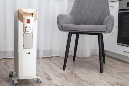 Modern electric heater in the kitchen in the apartment. The concept of heating a room without turning on the heating in the apartment in cold weather, industryの写真素材