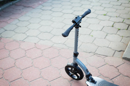 An electric scooter stands in the city against the background of road tiles. The concept of stealing scooters in the city.の写真素材