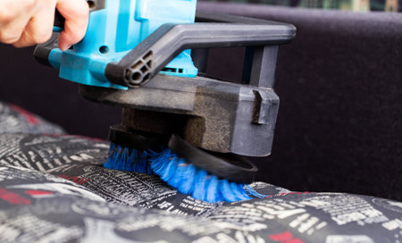 Dry cleaning of the sofa with a special electric brush to raise the pile, close-up, antibacterial treatmentの写真素材